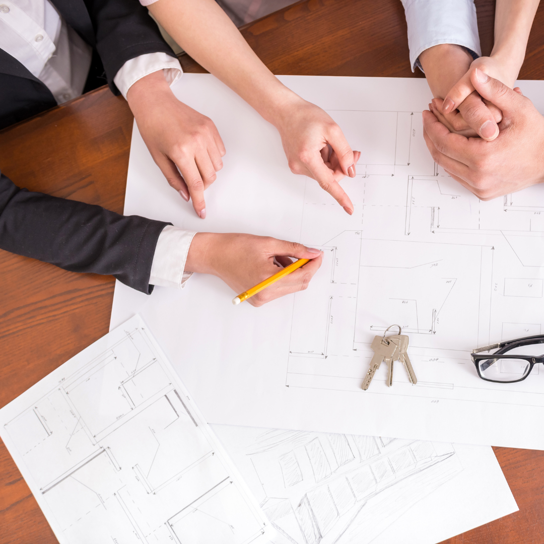 Realtor sitting at the table with clients planning a property